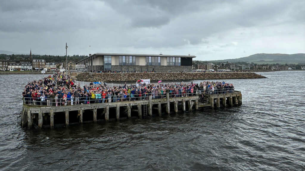 Save the Pier, Image courtesy of Waverley Excursions Ltd. A crowd of people holding a banner on Helensburgh Pier